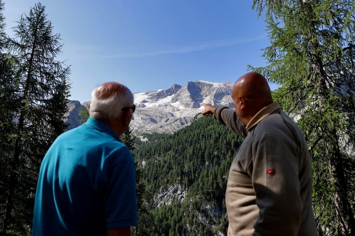 Dos personas observan la montaña de la Marmolada, donde tuvo lugar el desprendimiento del glaciar.