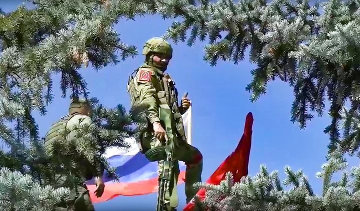 In this handout photo released by Russian Defense Ministry Press Service on July 3, 2022, Russian soldiers set a Russian national flag and a replica of the Victory banner atop of the administration after capturing the eastern village of Bilohorivka which is now a territory under the Government of the Luhansk People's Republic control, eastern Ukraine.
