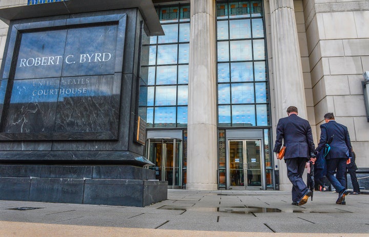 Huntington Mayor Steve Williams, left, and lawyer Rusty Webb enter the Robert C. Byrd United States Courthouse in Charleston, W.Va., on May 3, 2021, for the start of a trial in an opioid lawsuit filed by Cabell County and the city of Huntington against major drug distributors. 