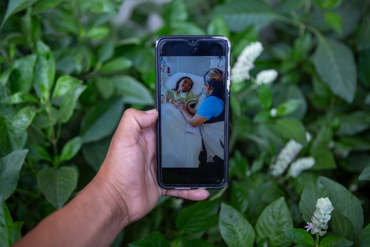 Mynor Cardona shows a photo on his cellphone of her daughter, Yenifer Yulisa Cardona Tomás, at the hospital while receiving a visit, in Guatemala City, Monday, July 4, 2022. Yenifer Yulisa Cardona Tomás is one of the survivors of the more than 50 migrants who were found dead inside a tractor-trailer near San Antonio, Texas.