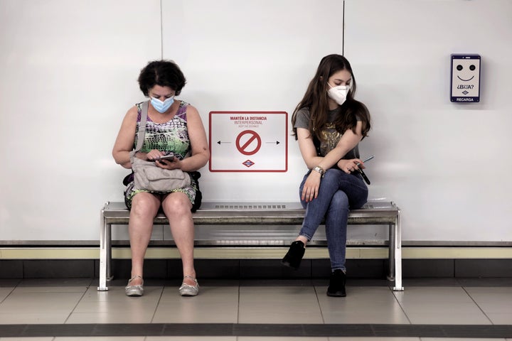 Dos personas con mascarilla en un andén del Metro de Madrid