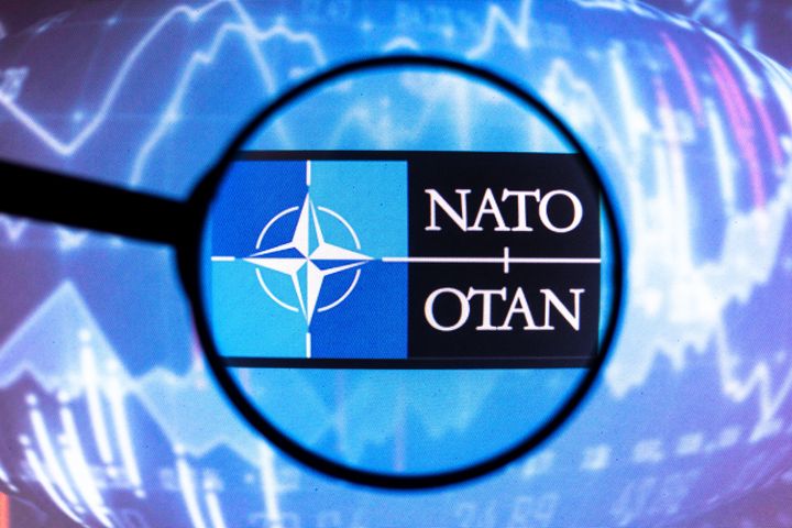 Imagen de archivo de una lupa sobre el logo de la OTAN.