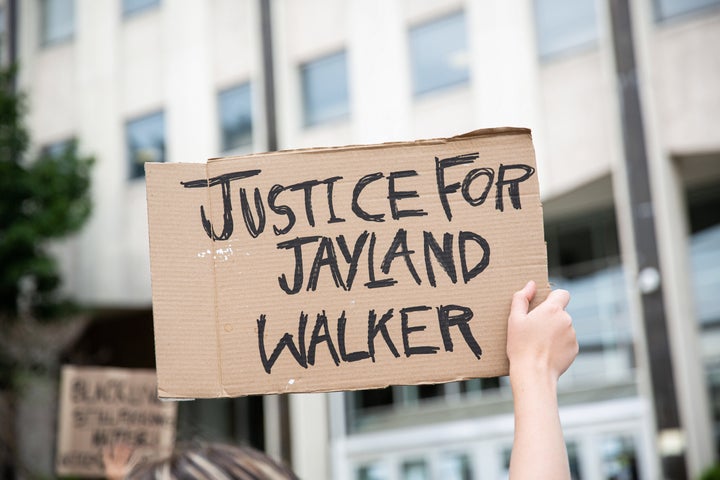 A protester holds a sign that says "Justice for Jayland Walker," a 25-year-old Black man police shot dozens of times after he tried to flee a traffic stop on June 27.
