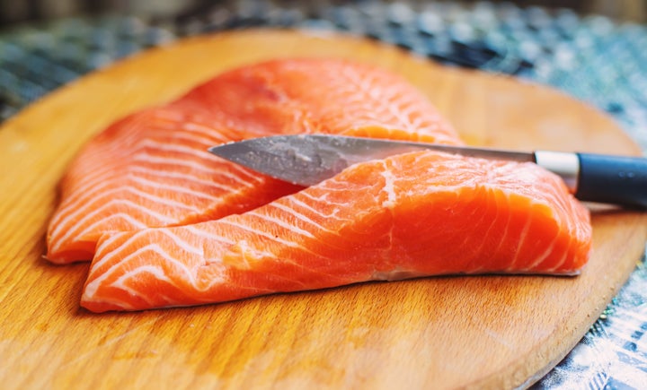 Red fish fillet cutting on the board. Selective focus. food.