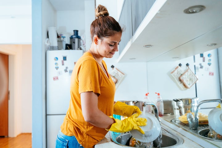 Beautiful young woman washing dishes