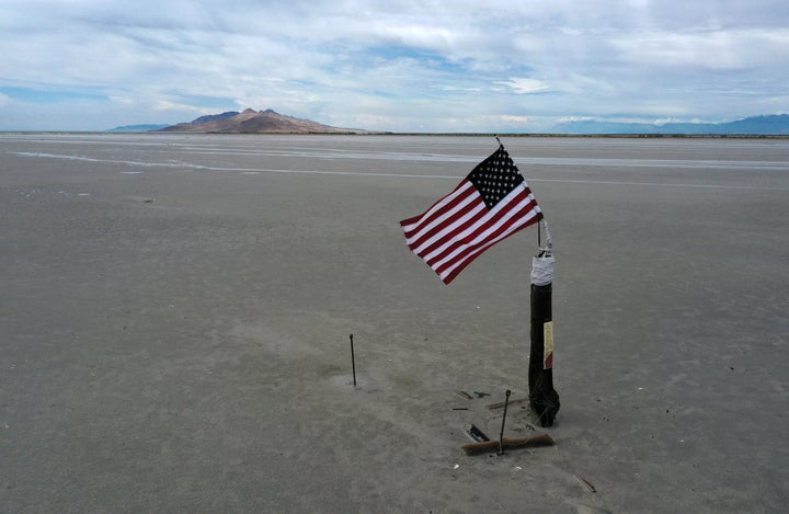 An American flag waves over a part of the Great Salt Lake that used to be underwater.