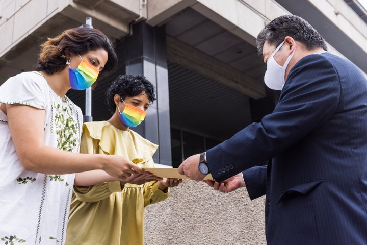 自民党の国会議員が参加する会合で性的マイノリティに差別的な冊子が配布されていたことに対し、党に内容の否定を求める要望書を提出した「Stand for LGBTQ+ Life」発起人のアンドロメダさん(左)と共同発起人のワインさん=2022年7月7日撮影、東京・永田町の自民党本部前