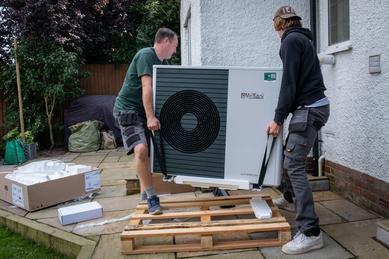 Workers from Solaris Energy install a Vaillant Arotherm air source heat pump unit in a 1930s-built house in Folkestone, U.K., in September 2021. The U.K. has heavily incentivized heat pumps.