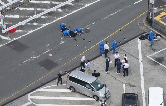 安倍晋三元首相が撃たれた現場付近を調べる警察官＝7月8日午後、奈良市