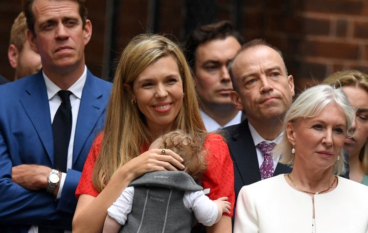 Carrie Johnson and daughter Romy listen as Boris Johnson makes a statement in front of 10 Downing Street in central London on July 7, 2022. 