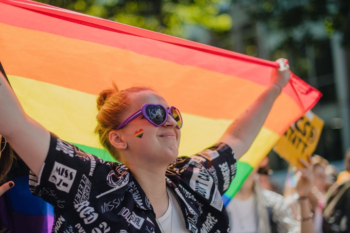 Foto de una mujer con la bandera LGTBI.