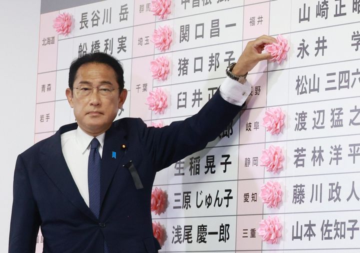 開票センターで当選確実の候補者名に花を付ける岸田文雄首相（自民党総裁）＝10日夜、東京都千代田区