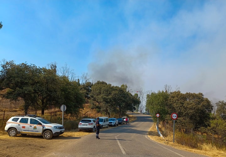 Acceso a una de las urbanizaciones en las que los servicios de emergencia han procedido al desalojo preventivo de una treintena de personas que se encontraban en viviendas ubicadas en el paraje de Lagos del Serrano, en El Ronquillo (Sevilla), como consecuencia del incendio forestal declarado.