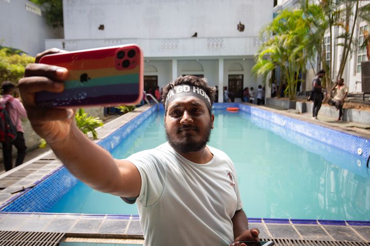 A protester takes a selfie near a swimming pool inside the presidential palace on July 13, 2022, in Colombo, Sri Lanka. 
