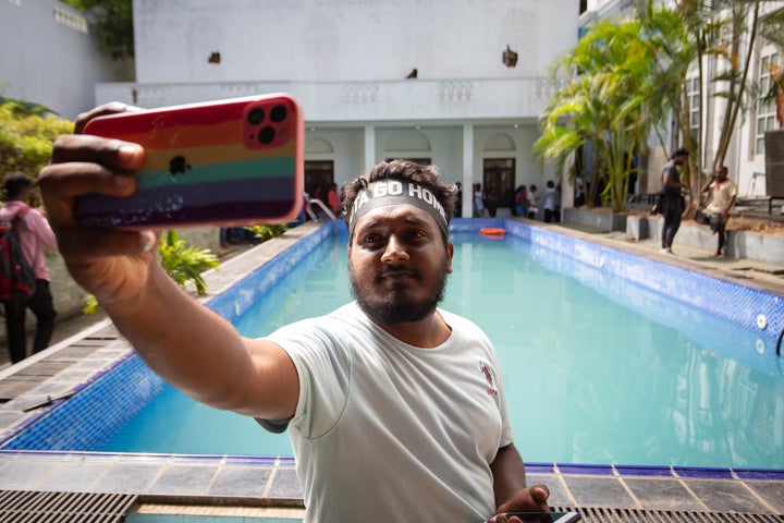 A protester takes a selfie near a swimming pool inside the presidential palace on July 13, 2022, in Colombo, Sri Lanka.