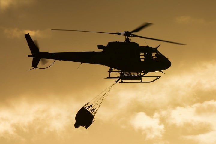 A helicopter flies during forest fire extinction works near Becerril de la Sierra, on the outskirts of Madrid, Tuesday, July 12, 2022.