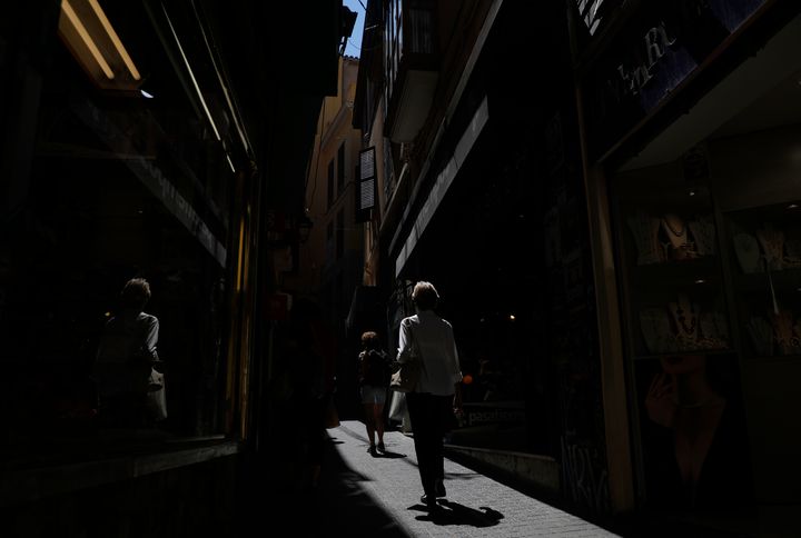 Dos mujeres pasan por una calle peatonal de tiendas en Palma de Mallorca, en plena ola de calor.