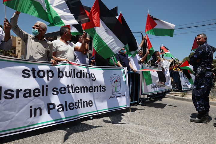 Palestinian security forces stand guard during a protest by locals waving national flags in Bethlehem in the occupied West Bank as US President Joe Biden visited Israel and the Palestinian territories, on July 15, 2022. -