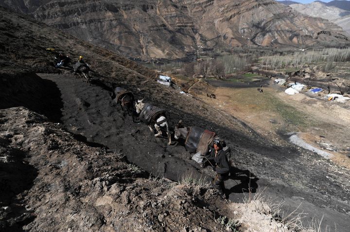 An Afghan miner walks up a slope outside a coal mine in Samangan Province, north of Kabul, on April 3, 2012.