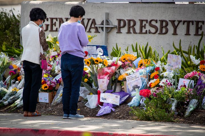 Mourners pause in front of a memorial in front of Geneva Presbyterian Church, in Laguna Woods, California, after a gunman killed one person and wounded four others in May.