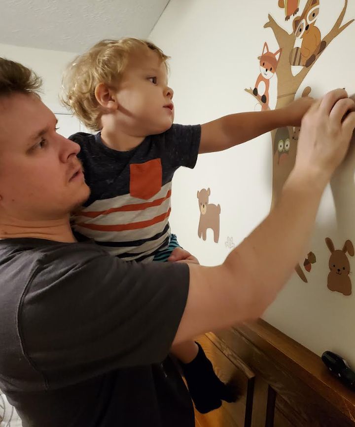 The writer's husband and oldest son decorate the nursery prior to the arrival of the unborn baby.