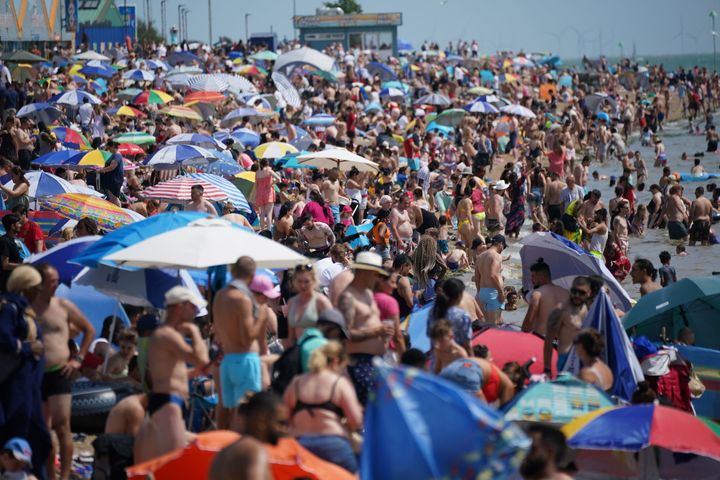 People relax on the beach at Southend-on-Sea on the Thames Estuary in Essex. Temperatures are predicted to hit 31C across central England on Sunday ahead of record-breaking highs next week. Picture date: Sunday July 17, 2022.