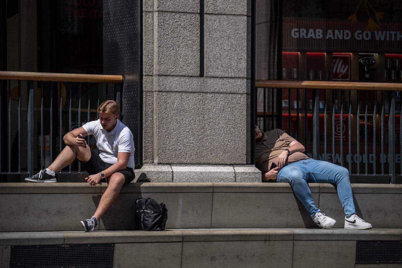 Men relax in the sun on Monday in London.