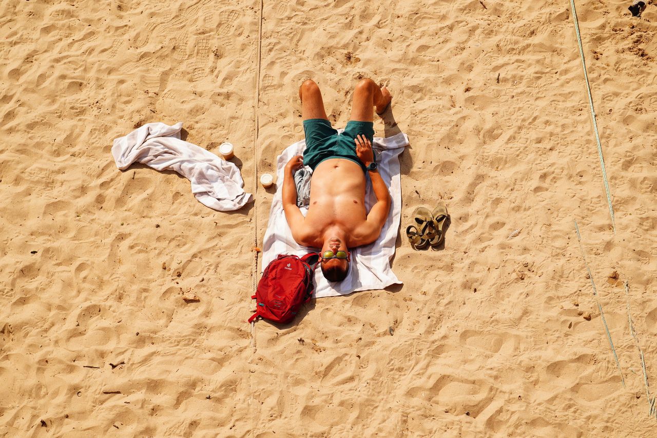 A man sunbathes on the beach in Mousehole, Cornwall, during the U.K.'s first red extreme heat warning on Monday.