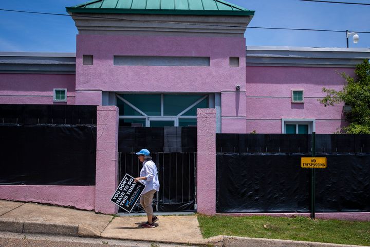 An anti-abortion protestor moves a sign from outside at the Jackson Womens Health Organization also known as the The Pink House in Jackson, MS on June 7, 2022.