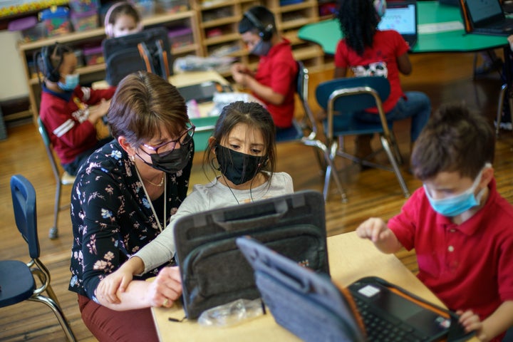 Kindergarten teacher Karen Drolet, left, works with a student at Raices Dual Language Academy, a public school in Central Falls, R.I., Feb. 9, 2022. Despite a year of disruptions, students largely made academic gains this past year that paralleled their growth pre-pandemic and outpaced the previous school year, according to new research released on July 19, 2022, from NWEA, a nonprofit research group that administers standardized tests.