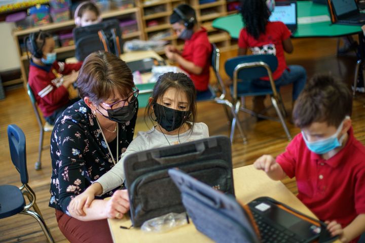 Kindergarten teacher Karen Drolet, left, works with a student at Raices Dual Language Academy, a public school in Central Falls, R.I., Feb. 9, 2022. Despite a year of disruptions, students largely made academic gains this past year that paralleled their growth pre-pandemic and outpaced the previous school year, according to new research released on July 19, 2022, from NWEA, a nonprofit research group that administers standardized tests. 