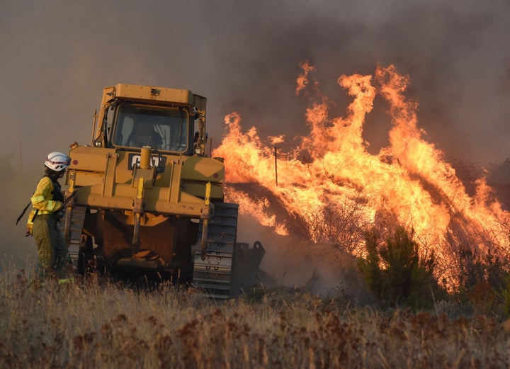 Varios bomberos utilizan un vehículo pesado para luchar contra el fuego en Tábara (Zamora)