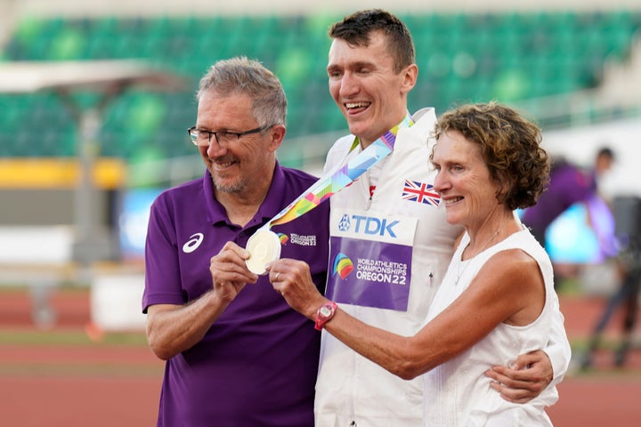 Geoff (left) and Susan Wightman pose with their son, gold medalist Jake Wightman, after the men's 1500-meter final run at the World Athletics Championships.