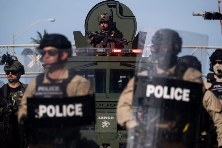 A police officer in military gear watches protesters from an armored vehicle during a May 31, 2020, rally in Miami in response to the police murder of George Floyd in Minneapolis a week earlier.