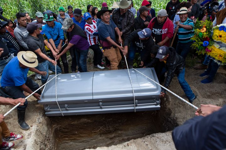 Neighbors and relatives lower the coffin that contain the remains of Pascual Melvin Guachiac Sipac into a freshly dug grave, in Tzucubal, Nahuala, Guatemala, on July 16, 2022. The 13-year-old was among a group of migrants who died of heat and dehydration in a trailer-truck abandoned by smugglers on the outskirts of San Antonio, Texas, on June 27.