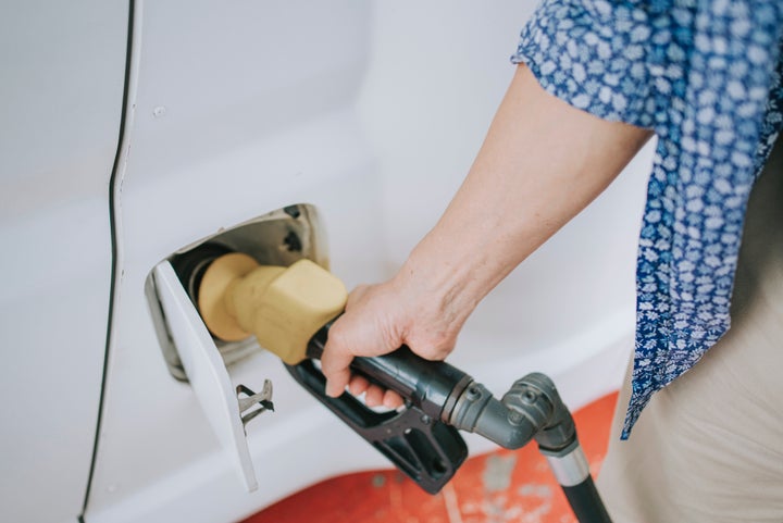 Un hombre carga gasolina en un vehículo.