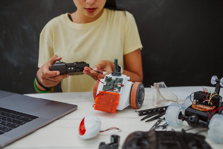 Una niña ensamblando un robot.