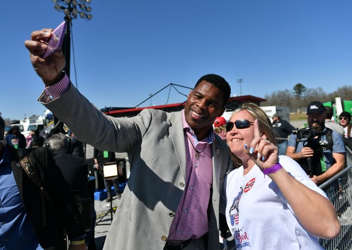 Republican Senate candidate Herschel Walker and a woman take a selfie during former President Donald Trump's "Save America" rally in Commerce, Georgia, on March, 26. (Photo by Peter Zay/Anadolu Agency via Getty Images)