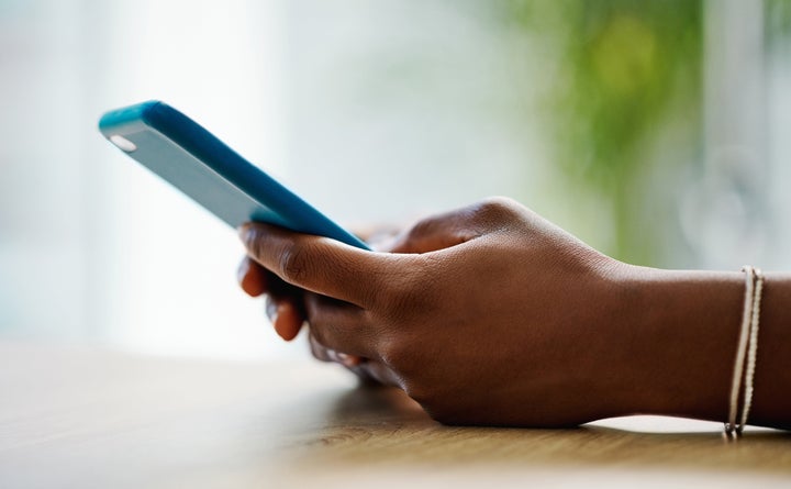 Side View Pleasant Millennial Mixed Race Woman Holding Smartphone