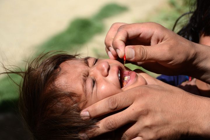 Un sanitario administra la vacuna de la polio a un niño durante una campaña de vacunación en Kandahar (Afganistán), en mayo de 2022.