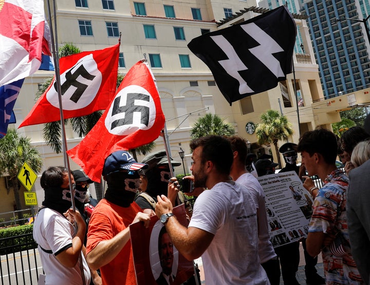 People waving Nazi swastika flags gather Saturday outside the Tampa Convention Center, where Turning Point USA Student Action Summit was being held.