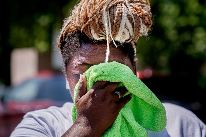 Nicole Brown wipes sweat from her face while setting up her beverage stand near the National Mall on July 22, 2022, in Washington.