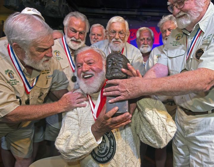 Jon Auvil, center, receives an Ernest Hemingway bust and congratulations after he won the 2022 Hemingway Look-Alike Contest at Sloppy Joe's Bar in Key West, Fla. 