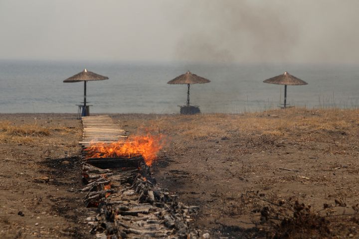 Ένας ξύλινος διάδρομος πάνω στην παραλία λαμπαδιάζει, καθώς μαίνεται η πυρκαγιά κοντά στο χωριό Βατερά, στο νησί της Λέσβου. Ελλάδα, 23 Ιουλίου 2022. REUTERS/Elias Marcou TPX IMAGES OF THE DAY