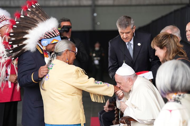 Pope Francis kisses the hand of residential school survivor Elder Alma Desjarlais in Edmonton, Alberta Sunday.