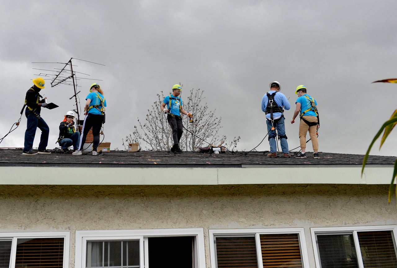 Students from the University of Michigan learn how to install a rooftop solar system at a home in Long Beach, California, in 2019. 