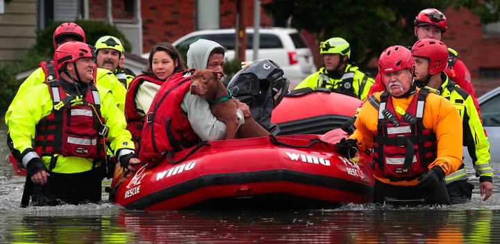 Matthew Robinson holds onto his dog Bebe as he and Kimberly Tat are rescued from their home by first responders from Central County Fire and Rescue along Main Street in Old Towne St. Peters after flooding from Dardenne Creek inundated the neighborhood during heavy rains on Tuesday, July 26, 2022. 