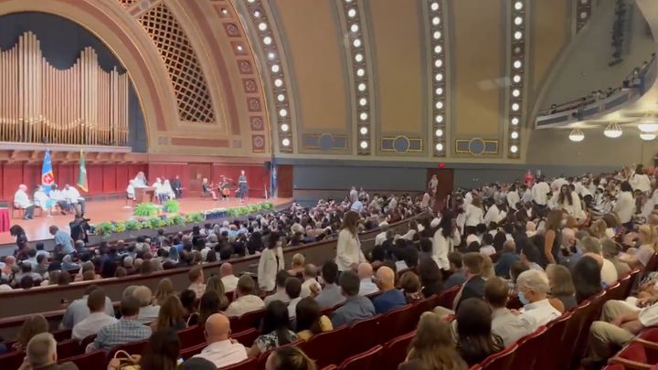 Dozens of incoming medical students at the University of Michigan walk out of the school’s annual White Coat Ceremony as Dr. Kristin Collier begins to speak.