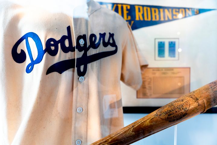 A Jackie Robinson's Brooklyn Dodgers uniform and bat on display at the Jackie Robinson Museum, Tuesday, June 26, 2022, in New York. (AP Photo/Julia Nikhinson)