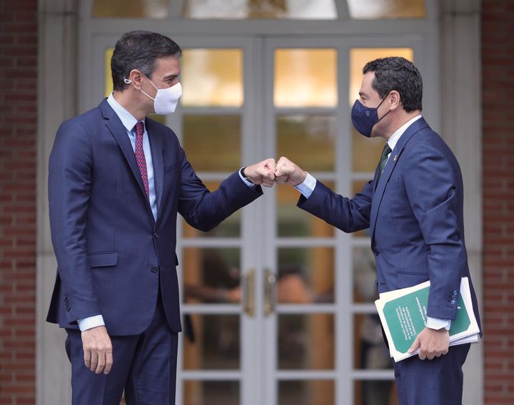 El presidente del Gobierno, Pedro Sánchez, saluda con el puño al presidente de la Junta de Andalucía, Juan Manuel Moreno Bonilla.